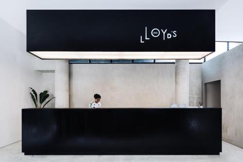 a man standing behind a black counter in a lobby at Lloyd's Inn Bali in Seminyak
