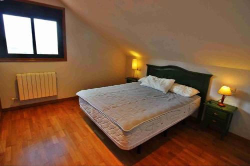 sypialnia z łóżkiem z 2 stolikami nocnymi i oknem w obiekcie Casa de O Rosal w mieście San Bartolomé
