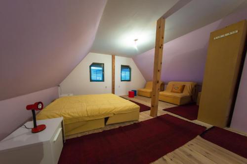 a bedroom with a yellow bed in a attic at Vikendica MM in Zlatibor