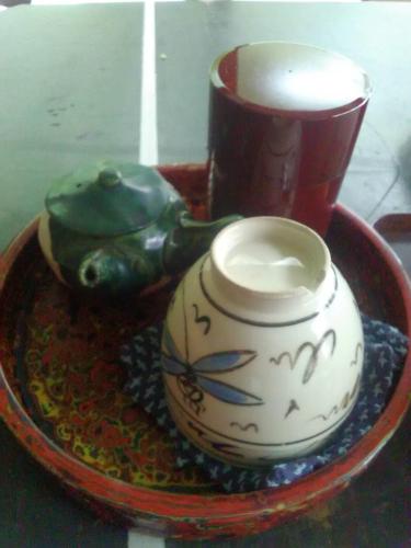 a tea pot and a cup on a plate at Chambre dhote Tatami in Suwa