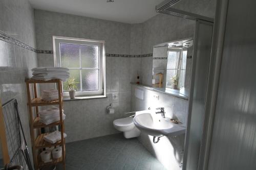 a bathroom with a sink and a toilet and a window at Apartment Friedenslinde in Bad Wörishofen