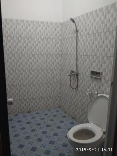 a bathroom with a toilet and a shower in it at Kumojoyo Homestay in Borobudur