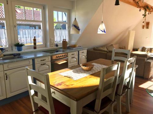 a kitchen with a wooden table and a table and chairs at Haus Jui in Zingst