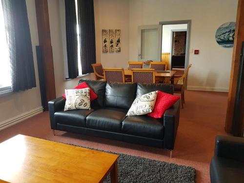 a living room with a black leather couch and a table at Abisko Lodge in Methven