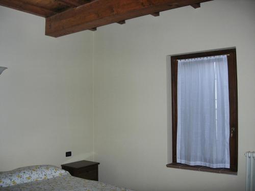 - une chambre avec un lit et une fenêtre dans l'établissement Agriturismo Campass, à Castelvetro Piacentino