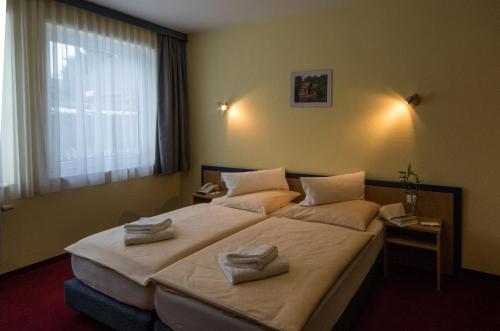 a hotel room with two beds with towels on them at Radduscher Hafen in Vetschau