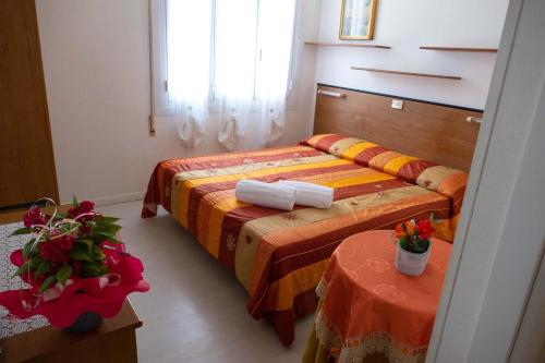 a hotel room with two beds and two tables at Hotel Fortuna in San Bartolomeo al Mare