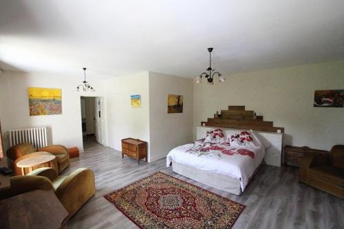 ein Schlafzimmer mit einem Bett und ein Wohnzimmer in der Unterkunft Domaine Du Moulin Neuf in Ambillou