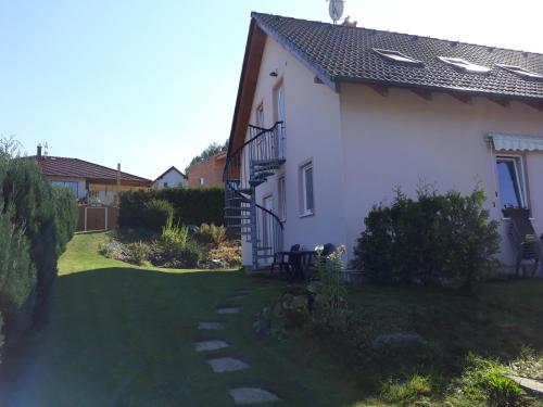 une maison blanche avec un jardin et une pelouse dans l'établissement Apartment U Krátkých, à Lipno nad Vltavou