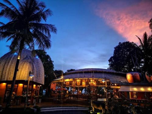 a building with a palm tree in front of it at The Mud - Eco Hotel in Ban Bang Po