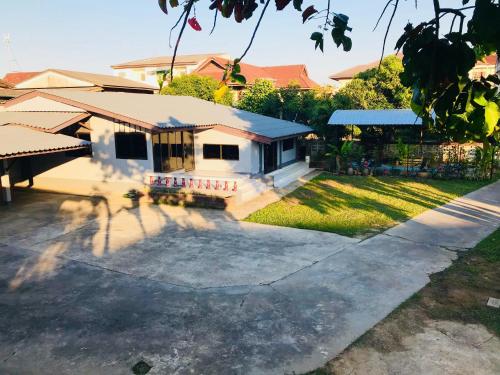 una casa con una gran entrada delante de ella en Winter House Chiang Rai en Chiang Rai