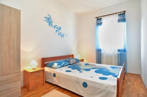 sypialnia z łóżkiem z niebieską kołdrą w obiekcie Apartment Edo 1755 w mieście Peresiji