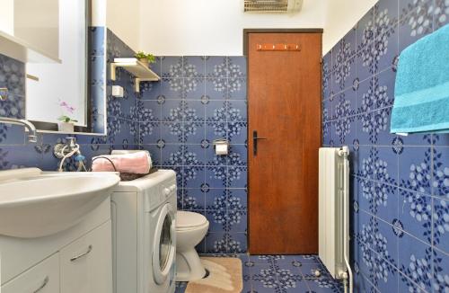 niebieska łazienka z toaletą i umywalką w obiekcie Apartment Edo 1755 w mieście Peresiji