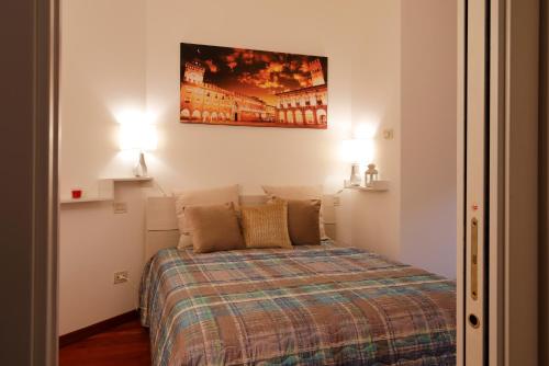 a small bedroom with a bed with two lamps at Bologna Central Apartment in Bologna