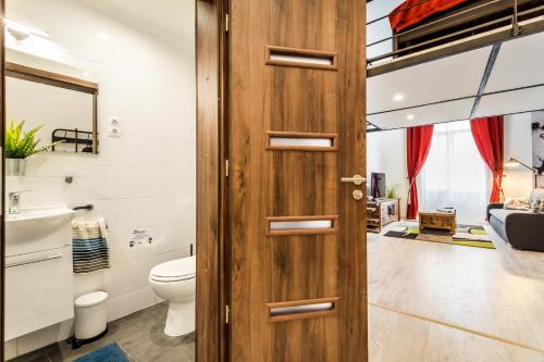 Baño con puerta de madera junto a un aseo en BpR Stupendous Design Home, en Budapest