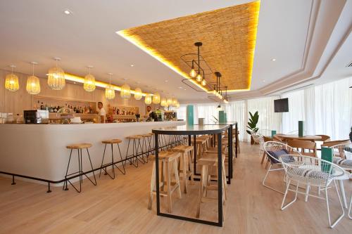 a restaurant with tables and chairs and a bar at Ipanema Park in El Arenal