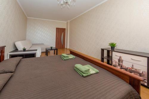 ポドリスクにあるApartment Rodnikiのベッドルーム1室(ベッド1台、緑のタオル2枚付)