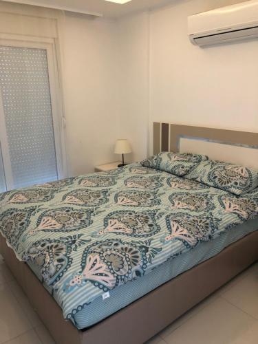 een slaapkamer met een bed met een deken erop bij Cozy apartment Centr Alanya in Alanya