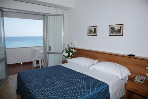 a bedroom with a bed and a view of the ocean at San Domenico Hotel in Soverato Marina
