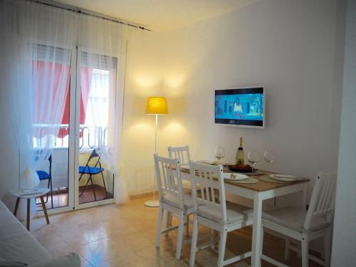 a dining room with a table and a tv on the wall at Amiga in Alicante