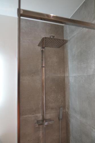 a shower with a shower head in a bathroom at B&B Ten Doele in Middelkerke