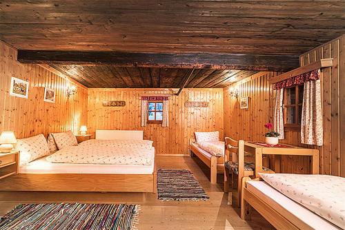 a bedroom with two beds in a room with wooden walls at Almliesl HUET-136 in Hüttschlag