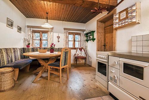 a kitchen and dining room with a table and a couch at Almliesl HUET-136 in Hüttschlag