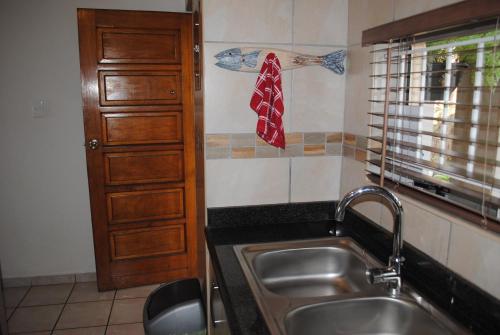 a kitchen with a sink and a towel on the wall at 5 Key Largo in Amanzimtoti
