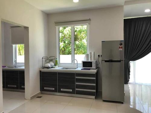 a kitchen with a sink and a refrigerator at Greenville Homestay in Balik Pulau