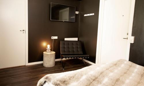 a bedroom with a black wall and a black chair at Sure Hotel by Best Western Algen in Östersund