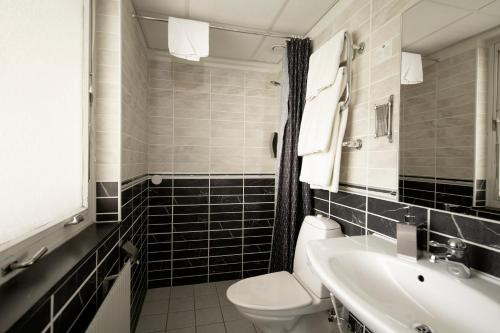 a bathroom with a toilet and a sink at Sure Hotel by Best Western Algen in Östersund