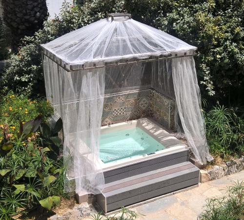 a hot tub in a greenhouse in a garden at Orpheas Resort Hotel (Adults Only) in Georgioupolis