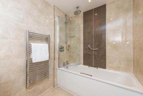 a bathroom with a bath tub and a shower at Macdonald Inchyra Hotel & Spa in Falkirk