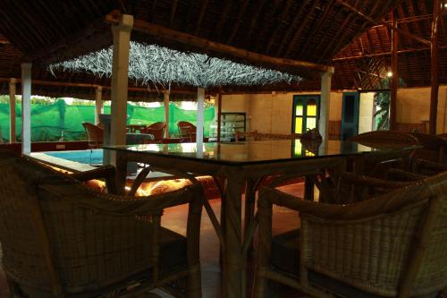 a dining room with a table and chairs at Malgudi Farms in Bangalore