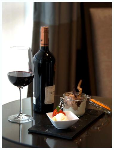 a glass of wine and a bowl of food and a bottle of wine at Casa Grande Hotel in La Paz