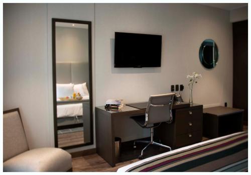 a hotel room with a desk and a mirror at Casa Grande Hotel in La Paz