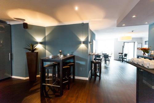 a restaurant with a bar with stools and tables at Hotel am Rothenbaum in Hamburg