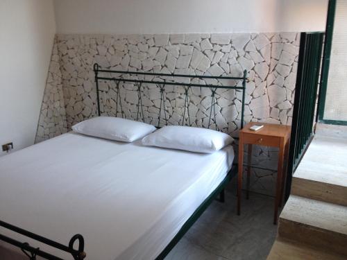 a bed with two pillows on it in a room at La Casuccia in Ercolano