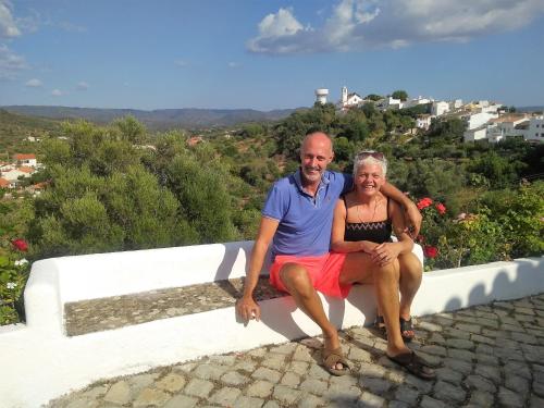 a man and a woman sitting on a wall at Casa dos Ninos in São Bartolomeu de Messines