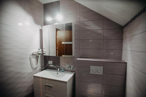a bathroom with a sink and a mirror at Pensiunea Jacqueline in Târgu Jiu