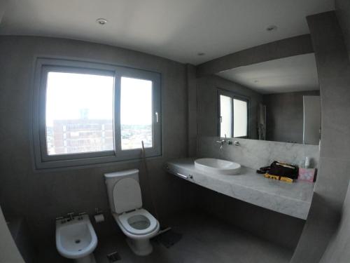 a bathroom with a toilet and a sink and a mirror at Departamento Villegas in Coronel Suárez