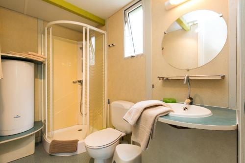 a bathroom with a sink and a toilet and a mirror at Camping Bungalows El Far in Calella