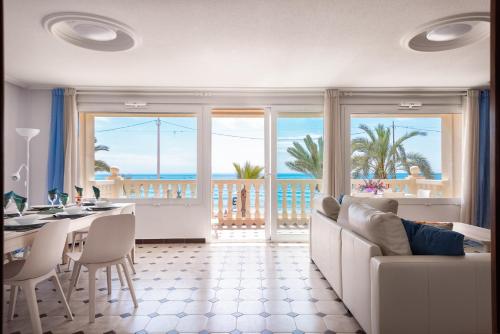 een woonkamer met een bank en een tafel met uitzicht op de oceaan bij Apartment front line Jakarta 1 Sea View in El Campello