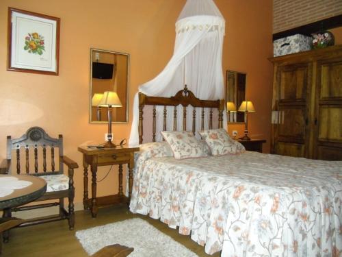 a bedroom with a bed and a table and a chair at Posada Herrán in Santillana del Mar