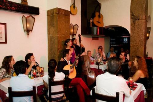 a group of people sitting at tables in a restaurant at Casa dos Ninos in São Bartolomeu de Messines
