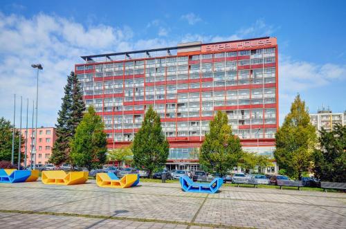 a building with a bunch of benches in front of it at STEELHOUSE Hotel in Třinec