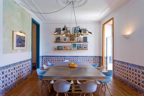 ein Esszimmer mit einem Holztisch und blauen Stühlen in der Unterkunft Lost Lisbon :: Chiado House in Lissabon