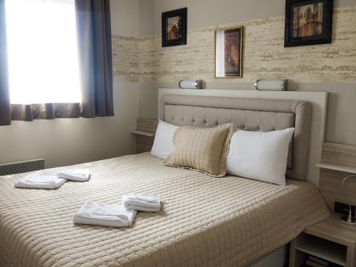 ein Schlafzimmer mit einem Bett, auf dem zwei Handtücher liegen in der Unterkunft Fabulous Luxury Apartment G7 in Kopaonik