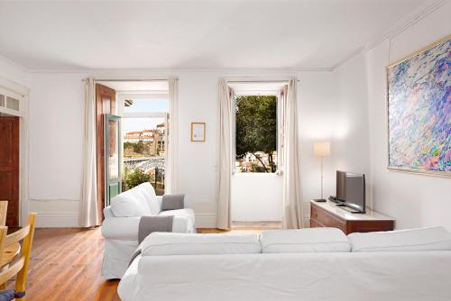 un soggiorno con 2 divani bianchi e una TV di Manor House Porto a Porto