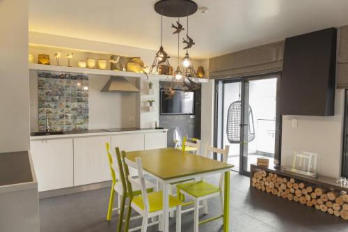 a kitchen with a dining room table and chairs at Graviana - Pedra Lima Charming House in Lagoa